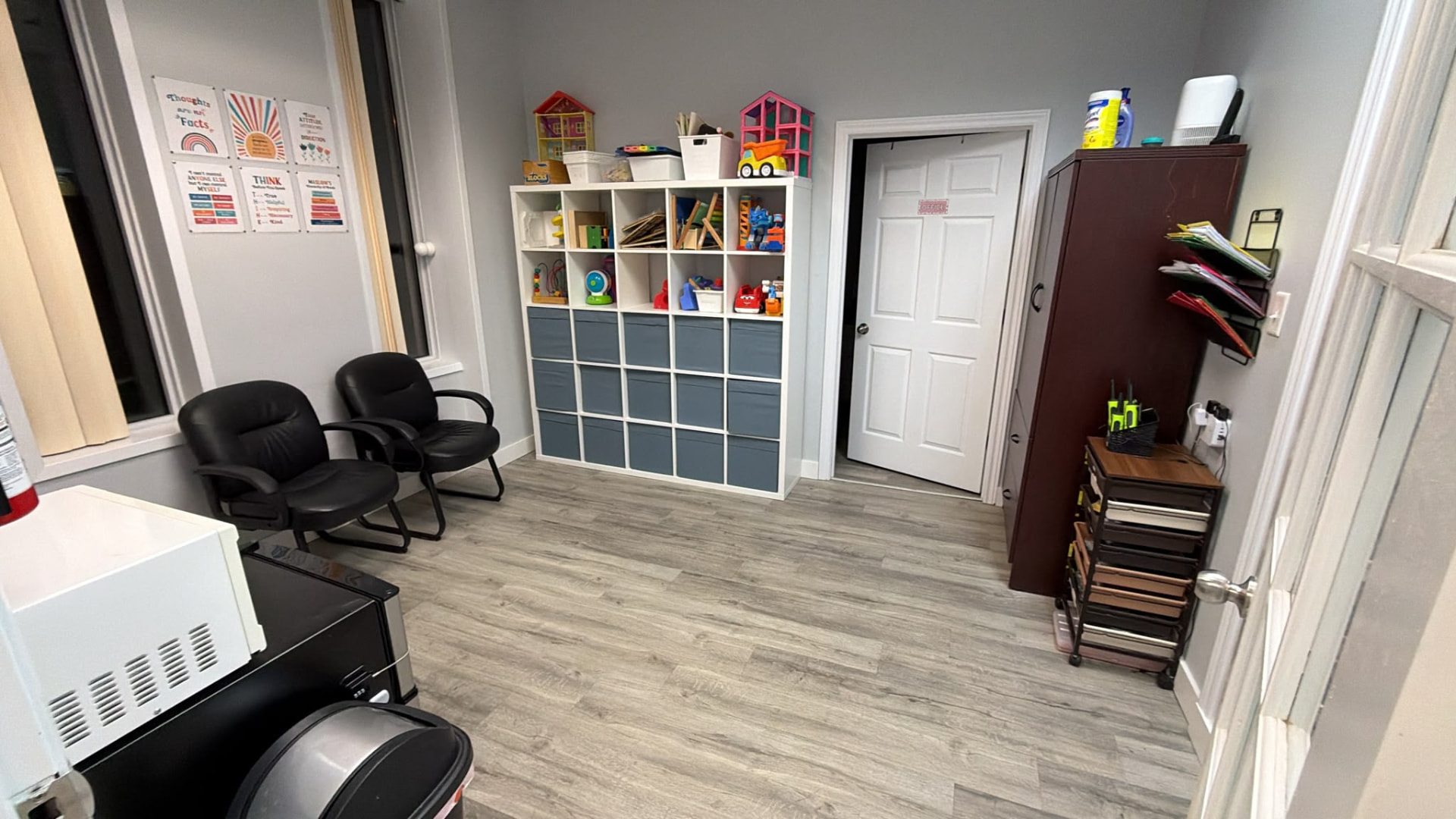 Clinic seating area with chairs and shelves of learning materials