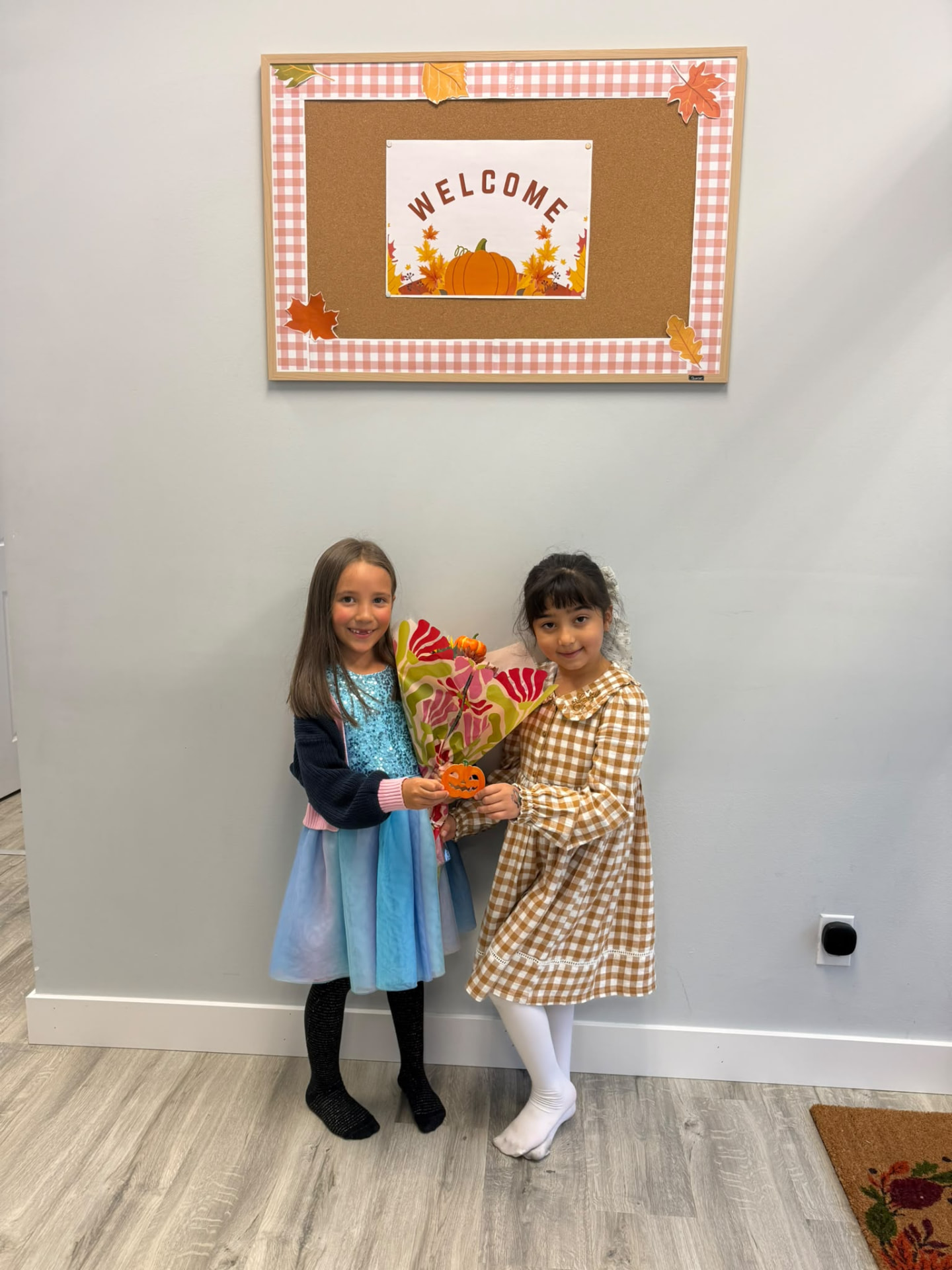 Two children standing together by a welcome display inside the clinic